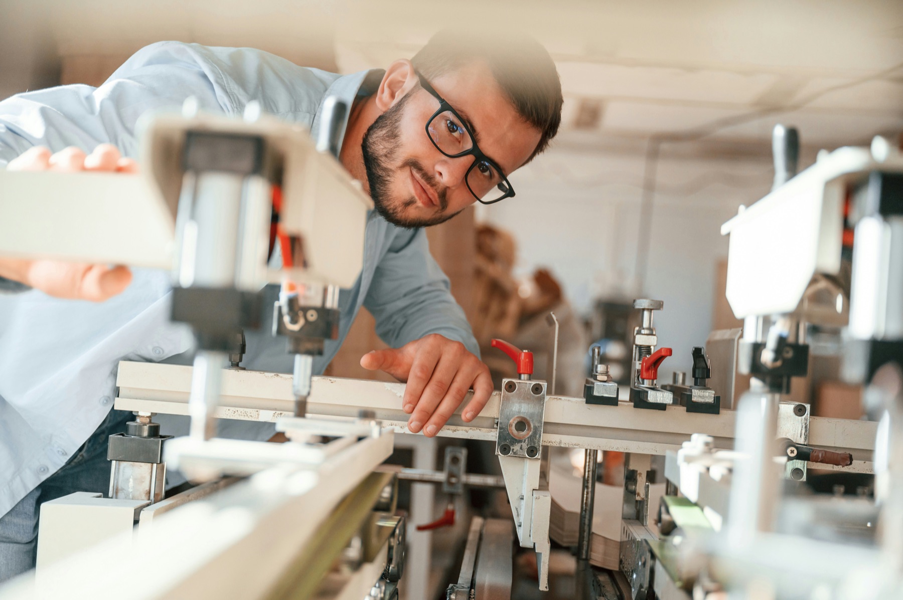 Technik w okularach sprawdza ustawienie elementów linii produkcyjnej